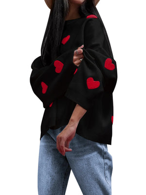 Black top with red heart patterns worn by a person on a white background