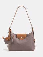 Gray handbag with brown accents on a light gray background