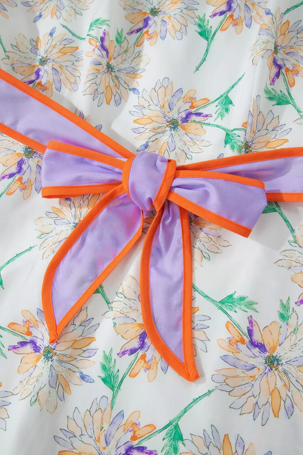 Floral dress with a large bow detail on a floral background