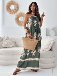 Woman in a green dress with white patterns holding a beige bag in a living room.