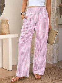 Person wearing pink checkered pants in a home setting