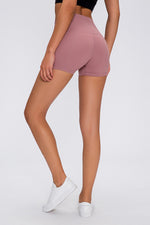 Person wearing pink high-waisted shorts on a white background