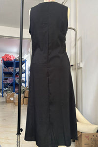Black sleeveless dress on a mannequin in a warehouse setting