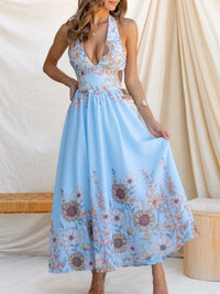 Woman wearing a light blue floral dress against a neutral background