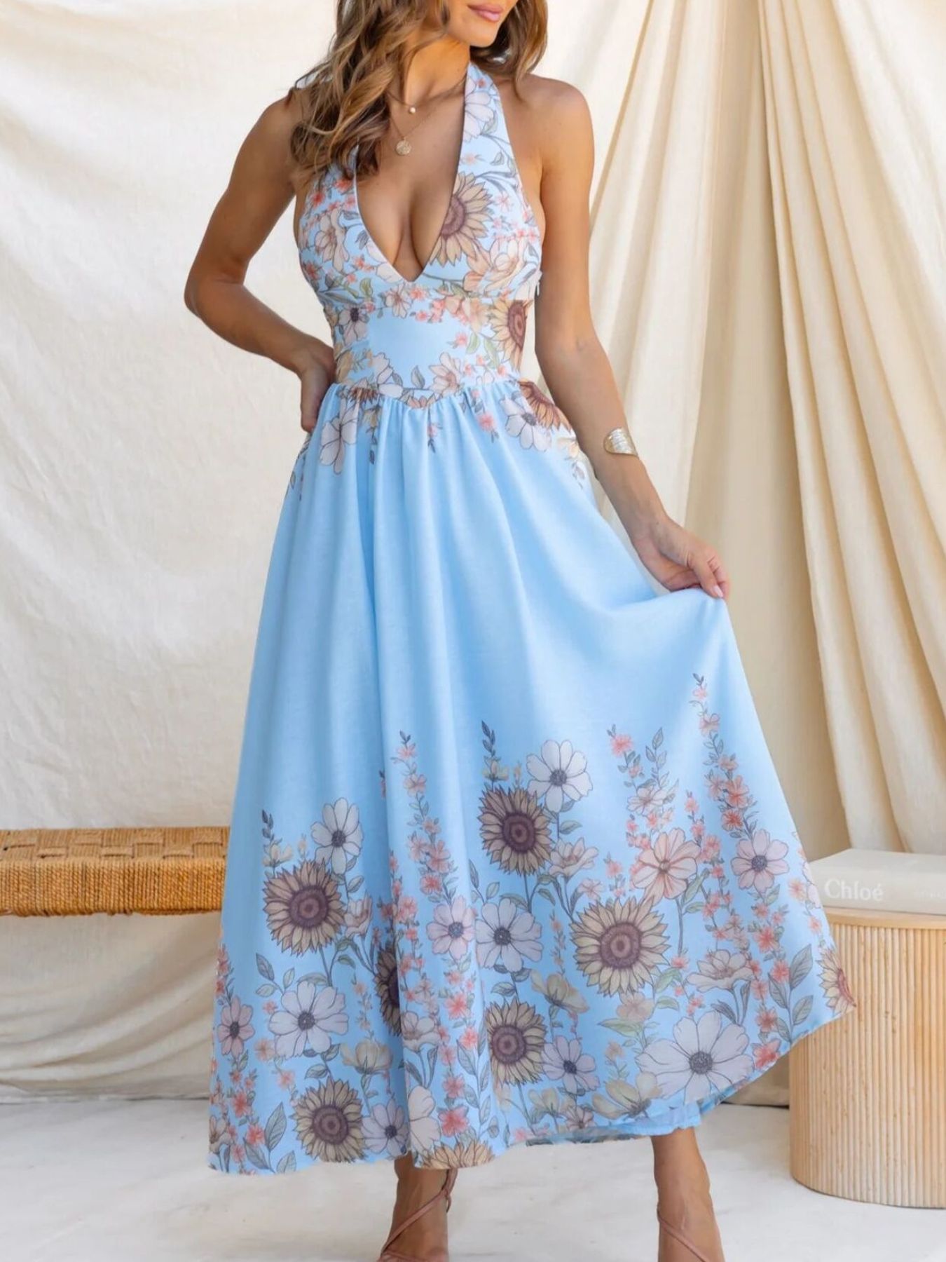 Woman wearing a light blue floral dress against a neutral background