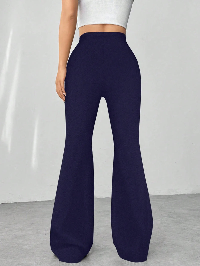 Navy blue flared pants worn by a person on a plain background