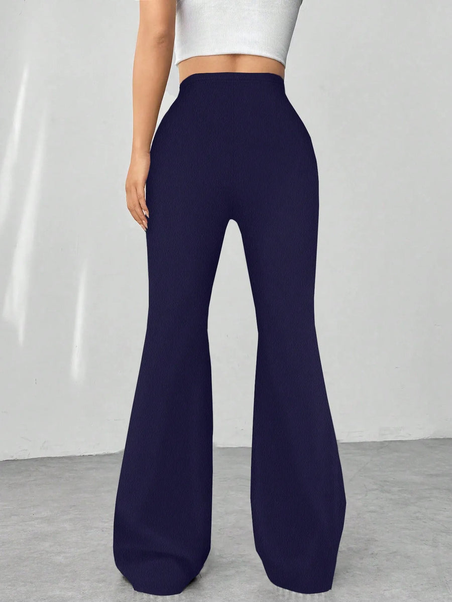 Navy blue flared pants worn by a person on a plain background