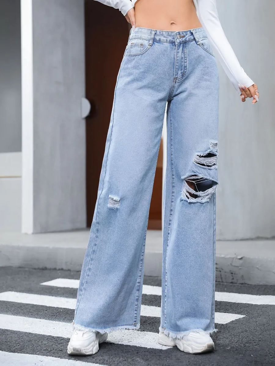 Light blue distressed wide-leg jeans worn by a person on a street.