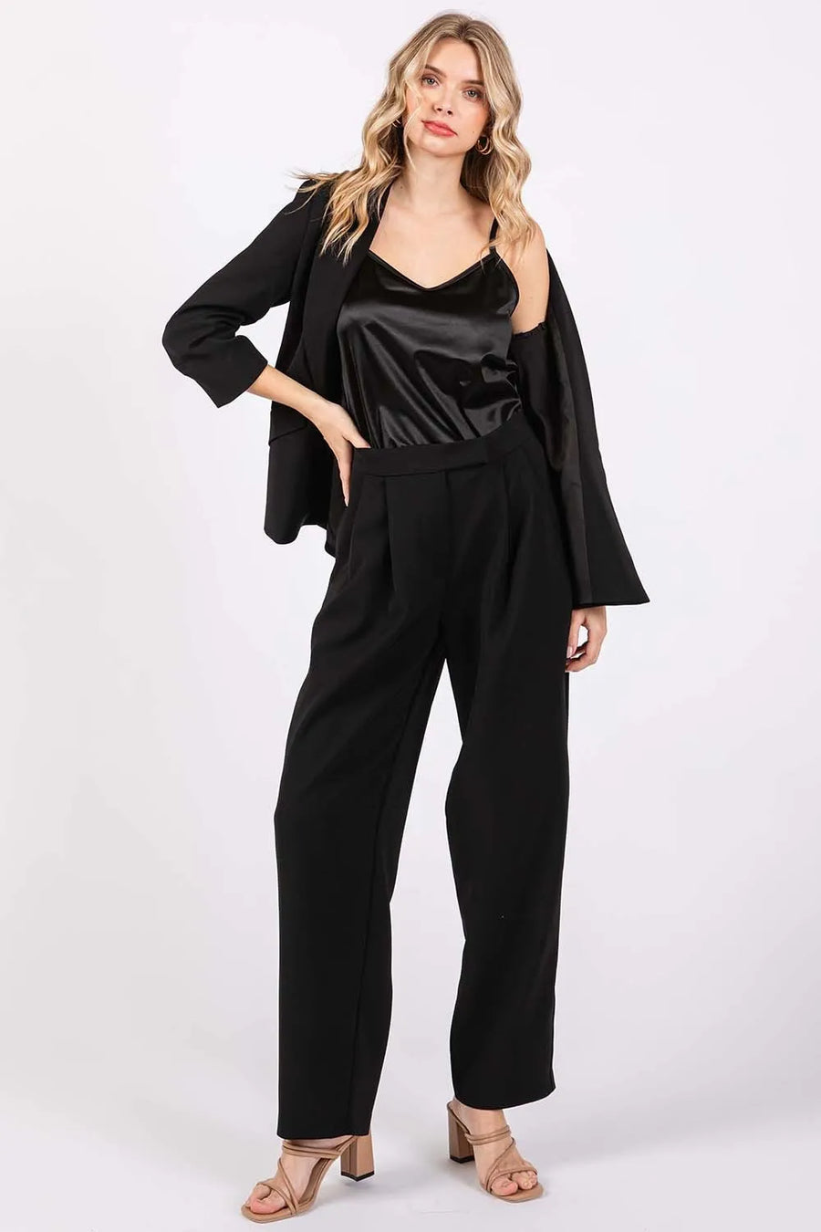 Woman wearing a black outfit with a jacket on a white background