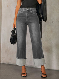 Person wearing gray wide-leg jeans with a plain background