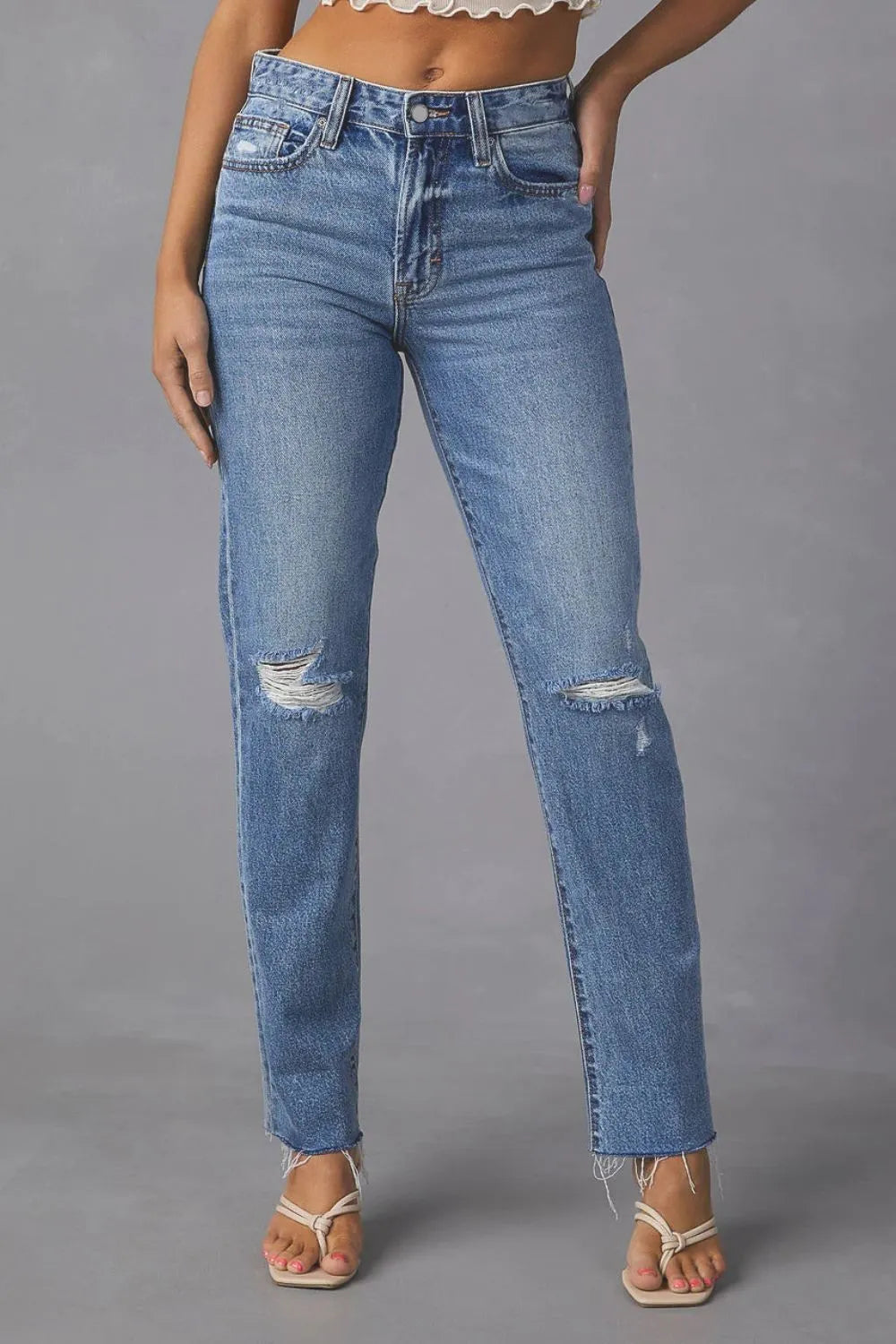 Blue jeans with slight distressing on a gray background
