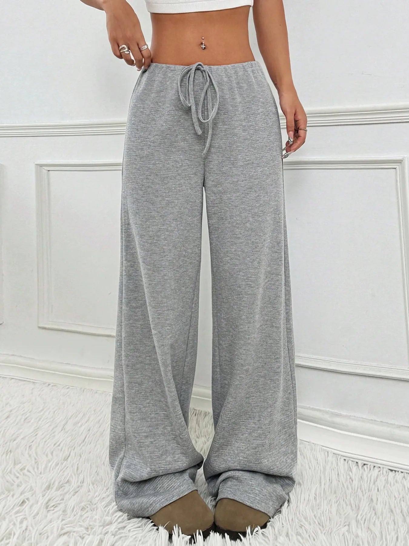 Gray sweatpants worn by a person on a white background