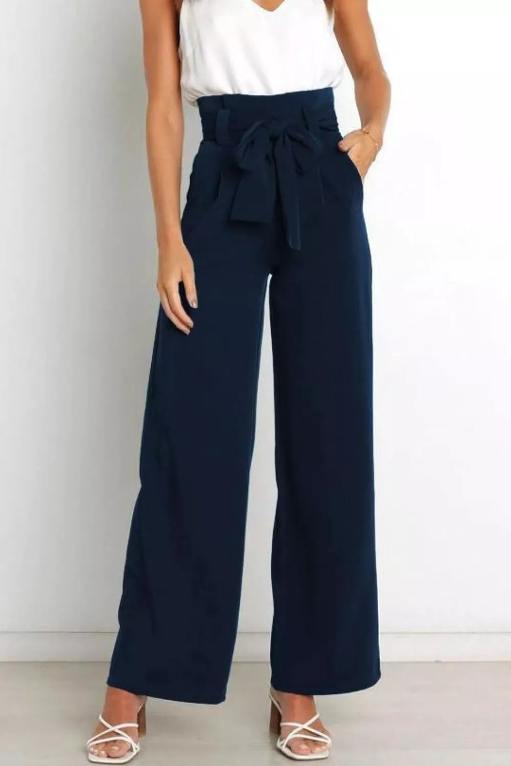 Navy wide-leg pants with a tie waist worn by a person on a white background