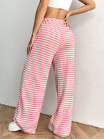 Person wearing pink and white striped pants on a plain background