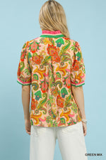 Woman wearing a colorful patterned shirt with a light blue background