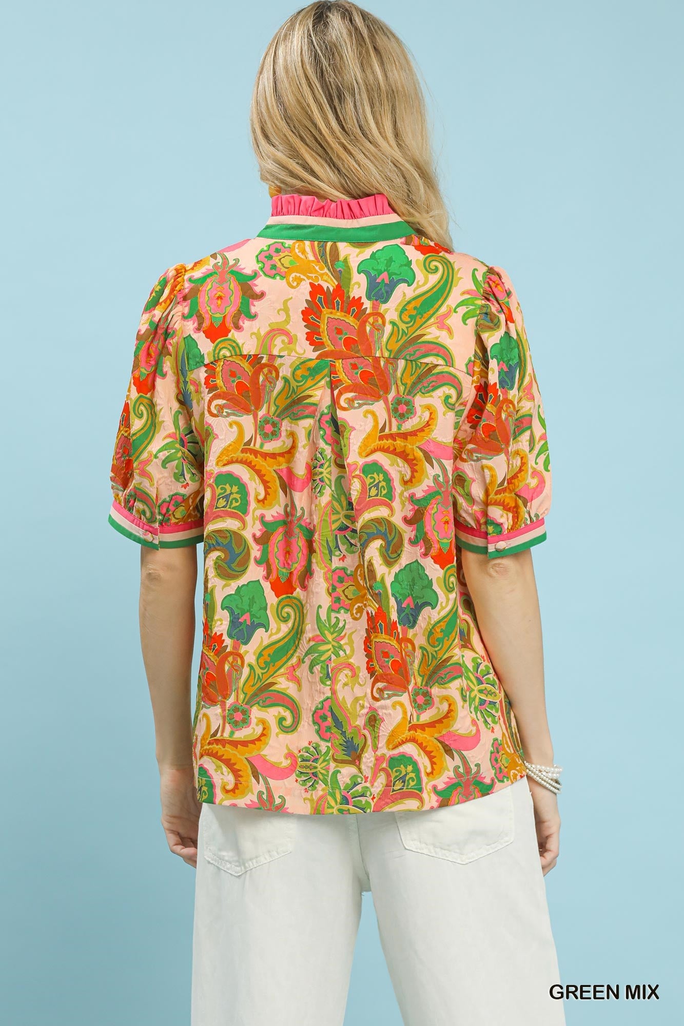 Woman wearing a colorful patterned shirt with a light blue background