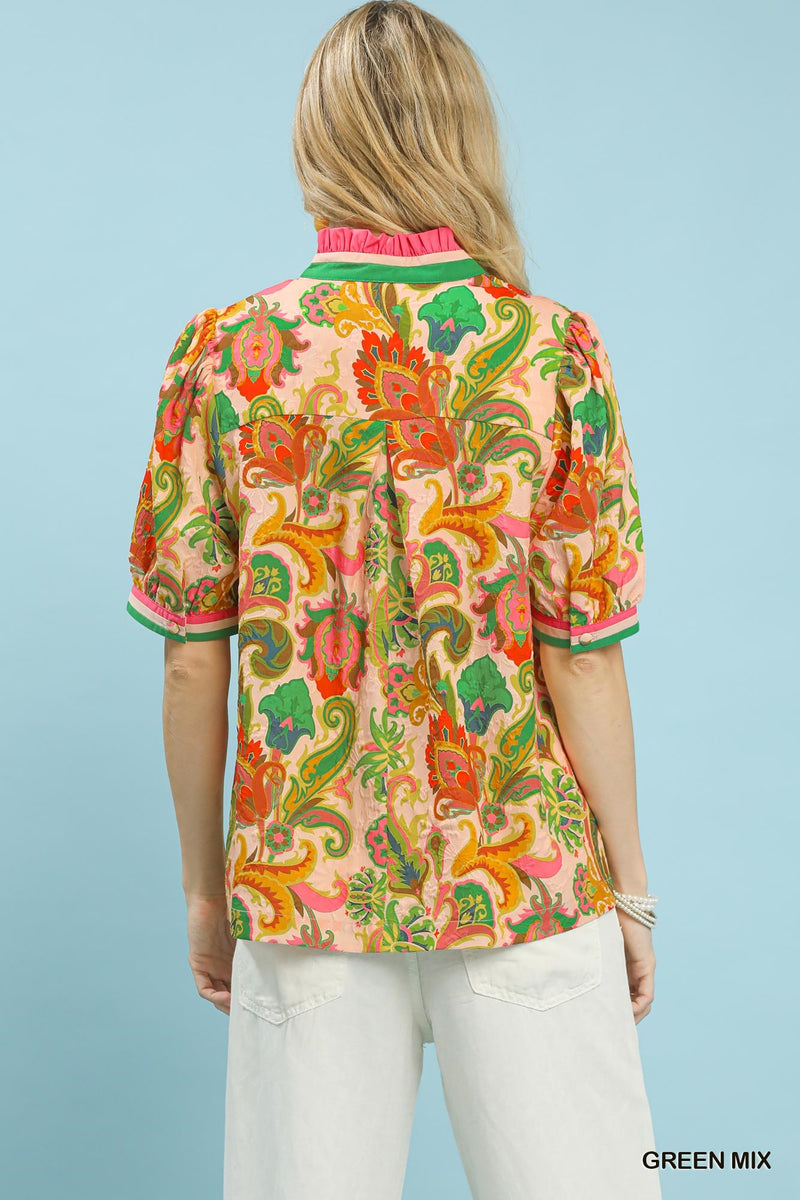 Woman wearing a colorful patterned shirt with a light blue background