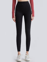 Person wearing black leggings with a plain background