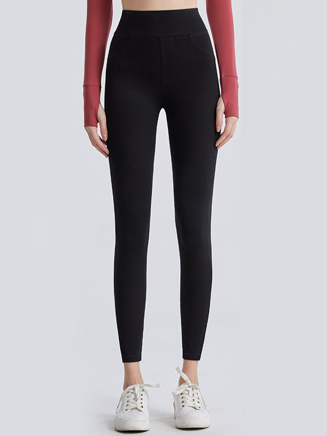 Person wearing black leggings with a plain background