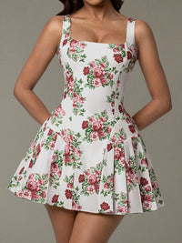 White dress with red floral pattern worn by a model on a gray background