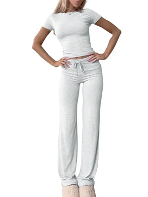 Woman wearing a white t-shirt and light gray sweatpants on a white background