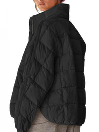Black puffer jacket worn by a person on a white background