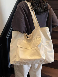 Beige tote bag worn by a person on a staircase