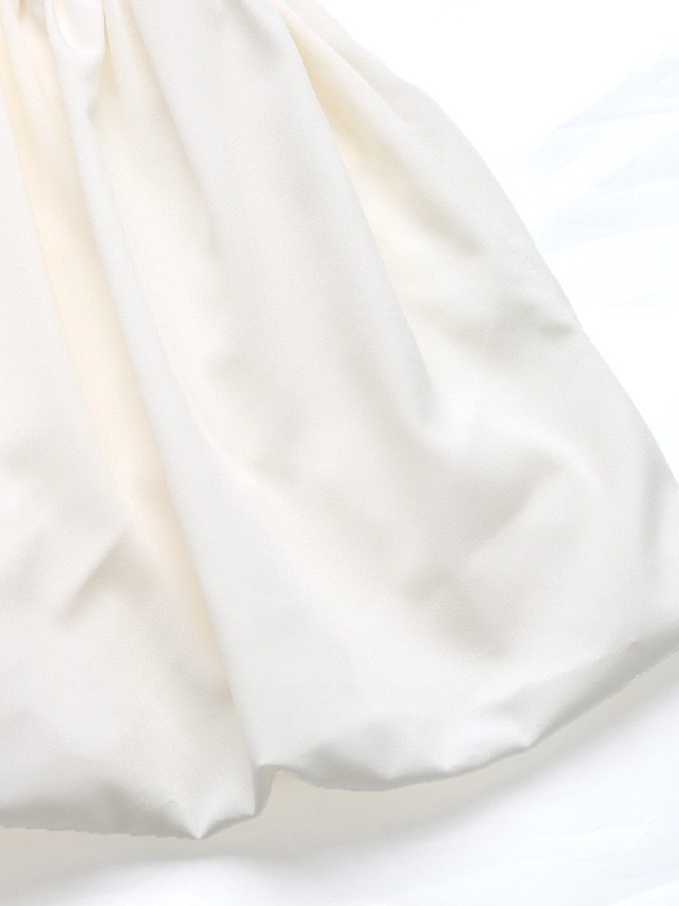 Close-up of white fabric with a subtle texture on a white background