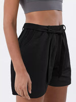 Black shorts worn by a person on a white background