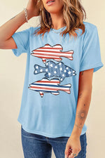 Person wearing a light blue t-shirt with fish graphic design on a beige background