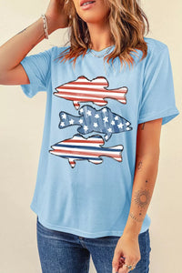 Person wearing a light blue t-shirt with fish graphic design on a beige background