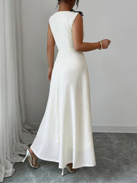 Woman wearing a long white dress against a neutral background