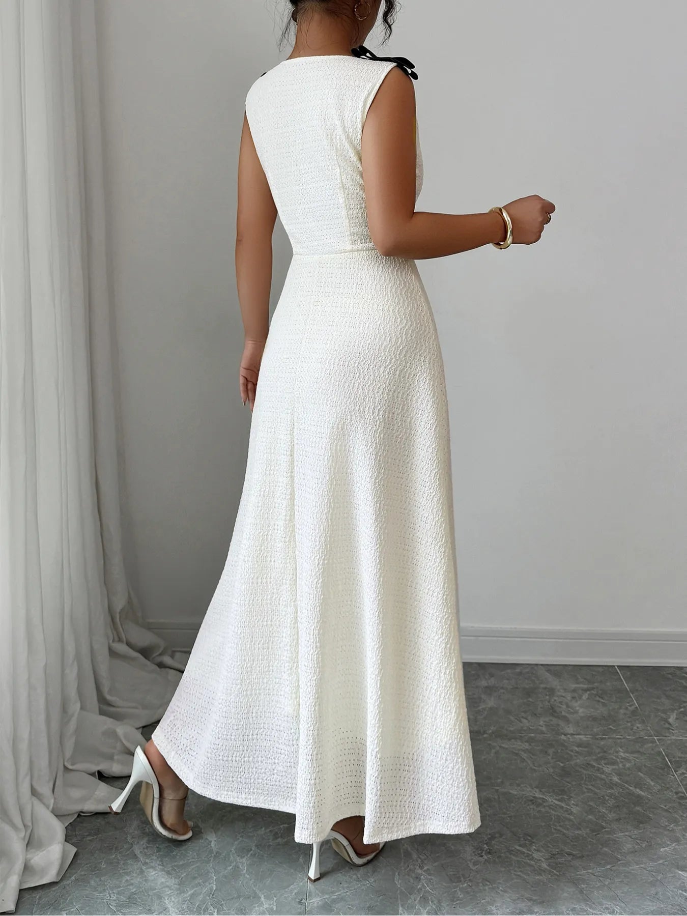 Woman wearing a long white dress against a neutral background