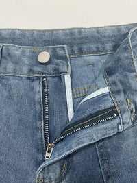 Close-up of blue denim jeans with a zipper and button on a light beige background