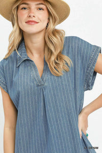 Woman wearing a blue striped dress and straw hat on a white background