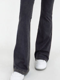 Black jeans worn by a person on a white background