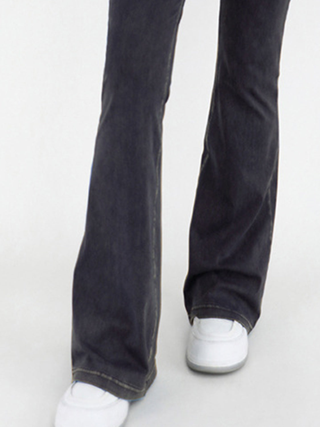 Black jeans worn by a person on a white background