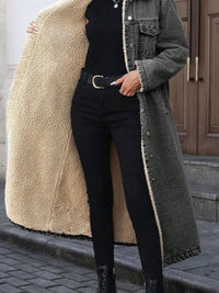 Person wearing a long coat with a beige sherpa lining, black pants, and black boots on a street.