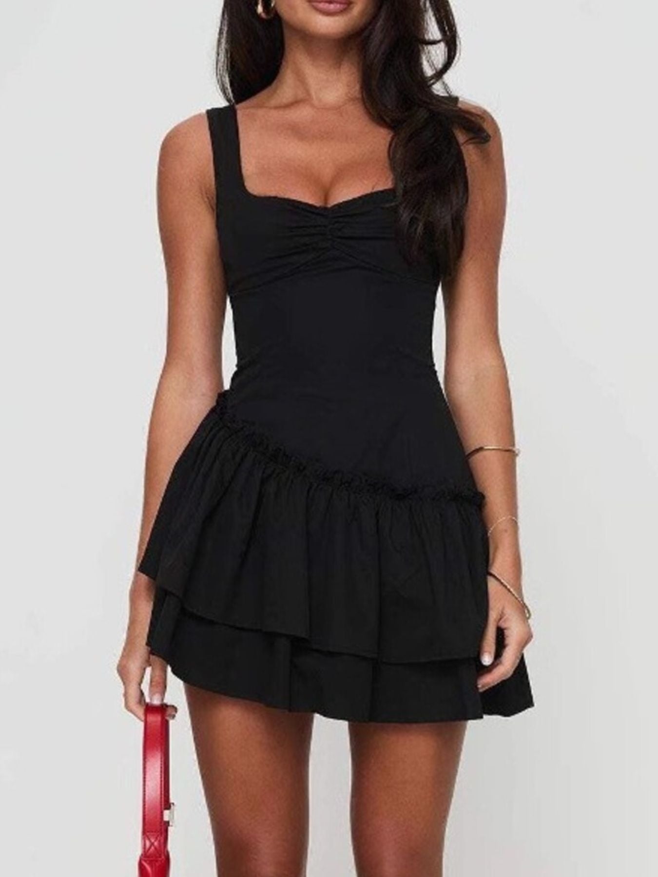 Black dress with ruffled layers worn by a model on a white background