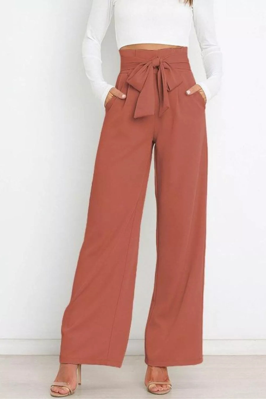 Brown wide-leg pants with a tie waist worn by a person on a white background
