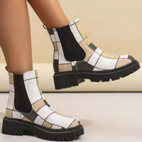 Patterned boots with a checkered design worn by a person on a neutral background