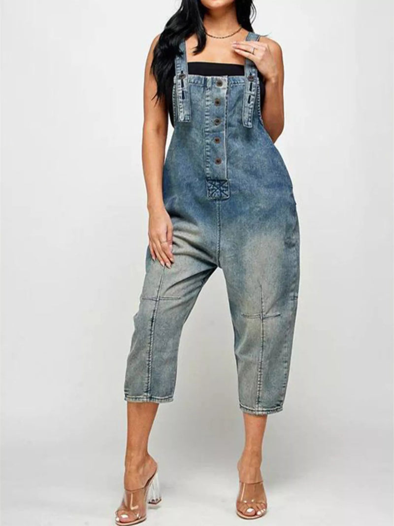 Person wearing a denim jumpsuit on a white background