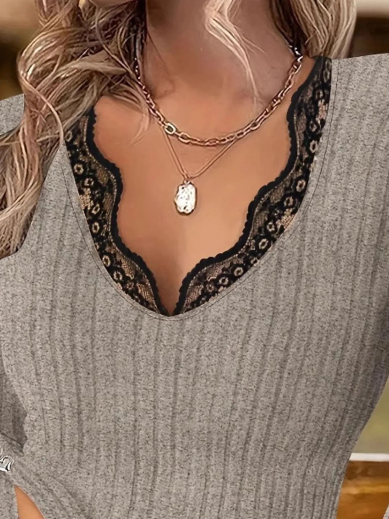 Gray ribbed sweater with black lace trim and a necklace.