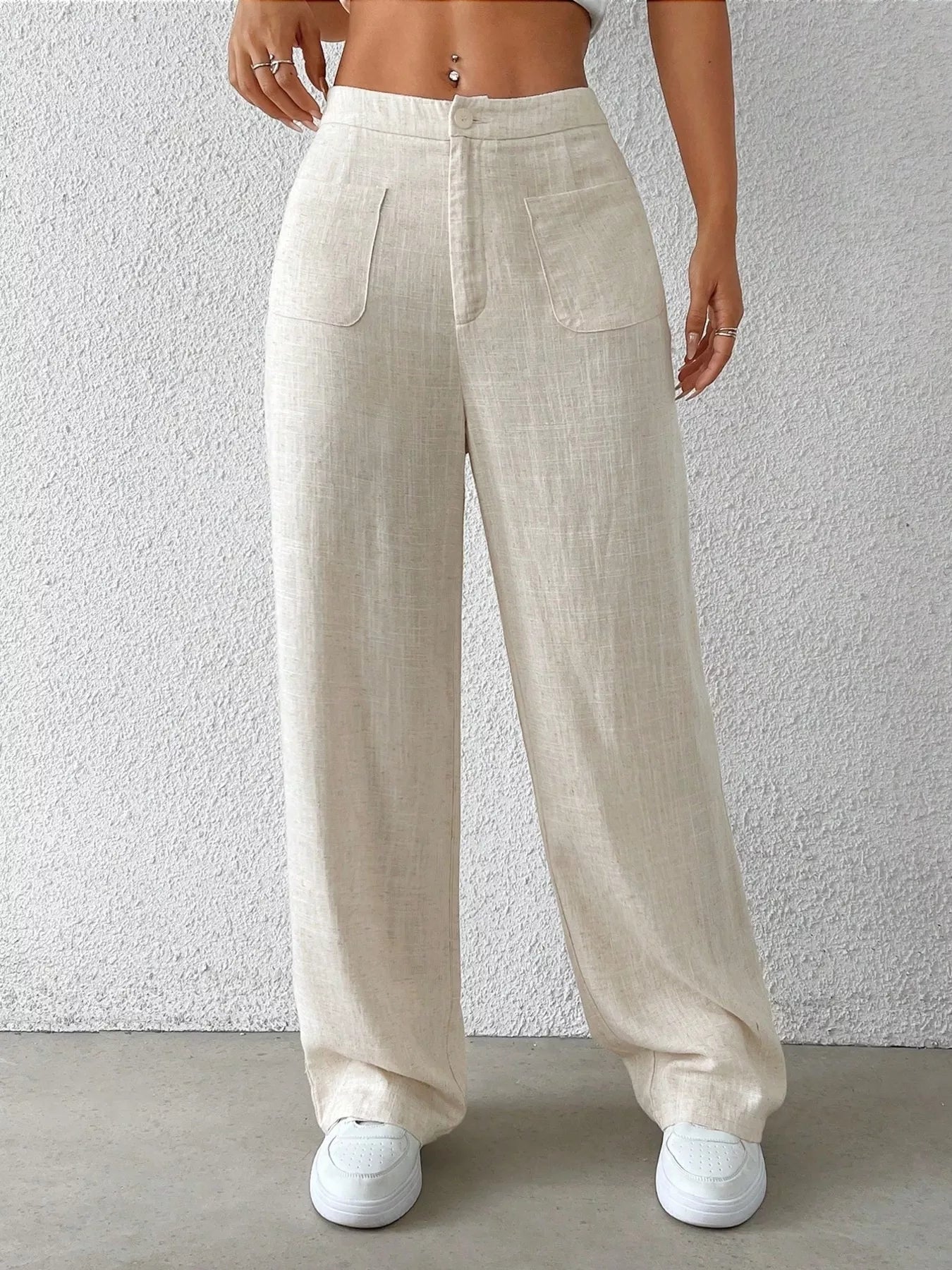 Beige linen pants worn by a person against a plain background