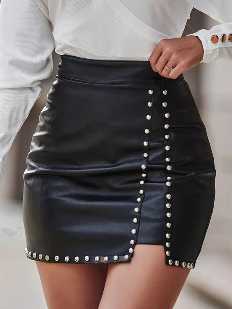 Black leather skirt with pearl embellishments worn by a person.