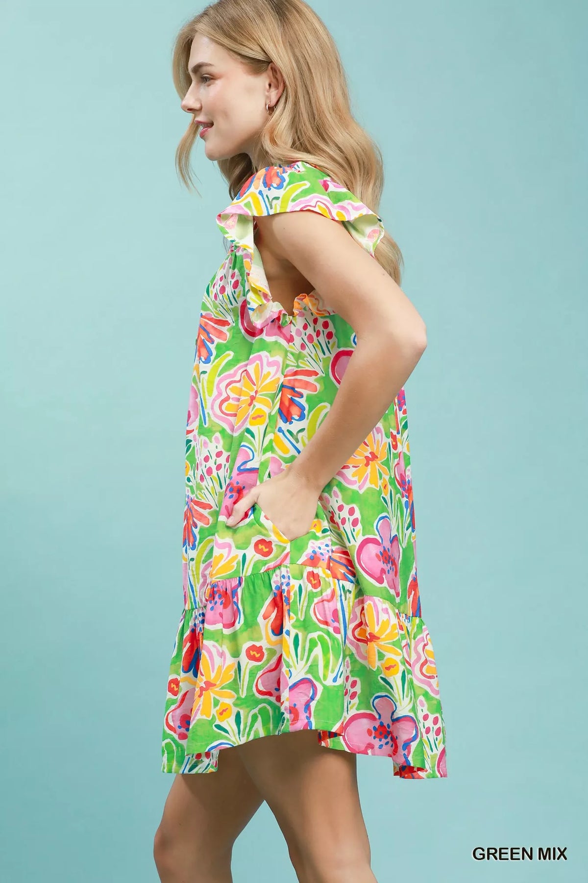 Woman wearing a colorful floral dress against a light blue background