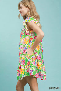 Woman wearing a colorful floral dress against a light blue background