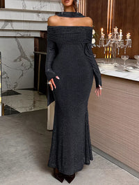 Woman wearing a black off-shoulder dress in an elegant indoor setting.