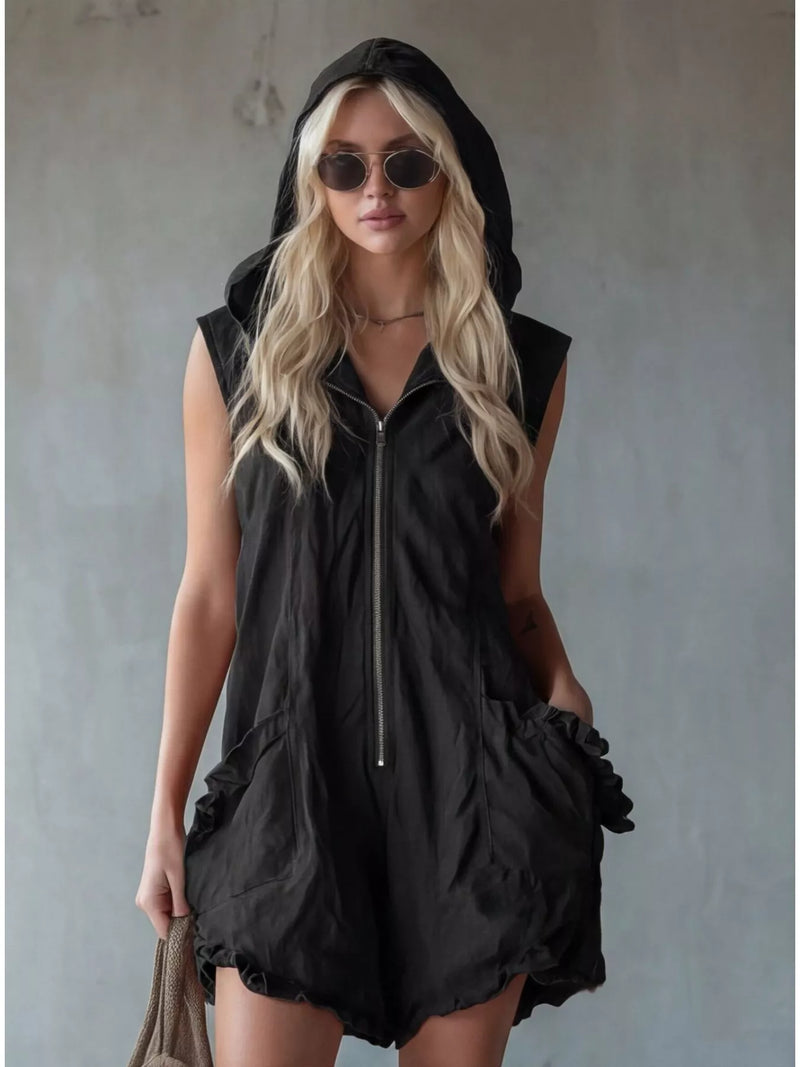 Woman wearing a black sleeveless hooded outfit against a plain background