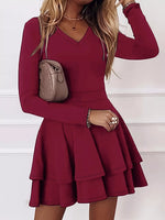 Red dress worn by a person with a beige handbag on a white background